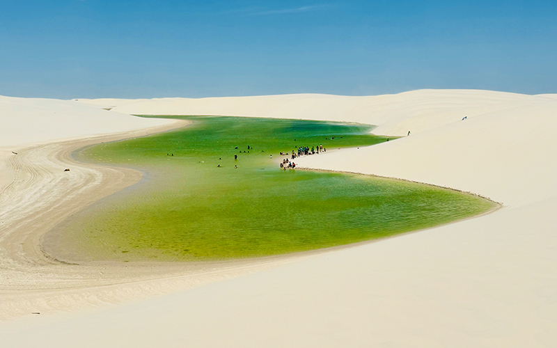 People swimming at blue lagoons at Parque Nacional Dos Lencois Maranhenses Brazil